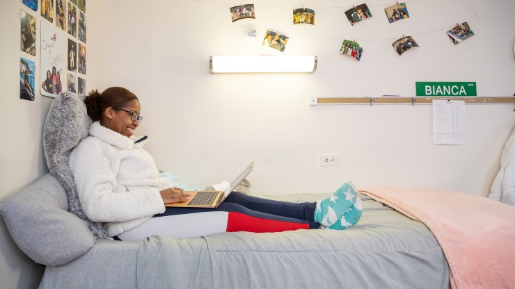 A student studies in her room within Prosser Hall.